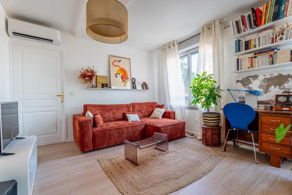 un salon avec un canapé rouge et un fauteuil bleu dans l'établissement Appartement Gorge de loup, à Lyon