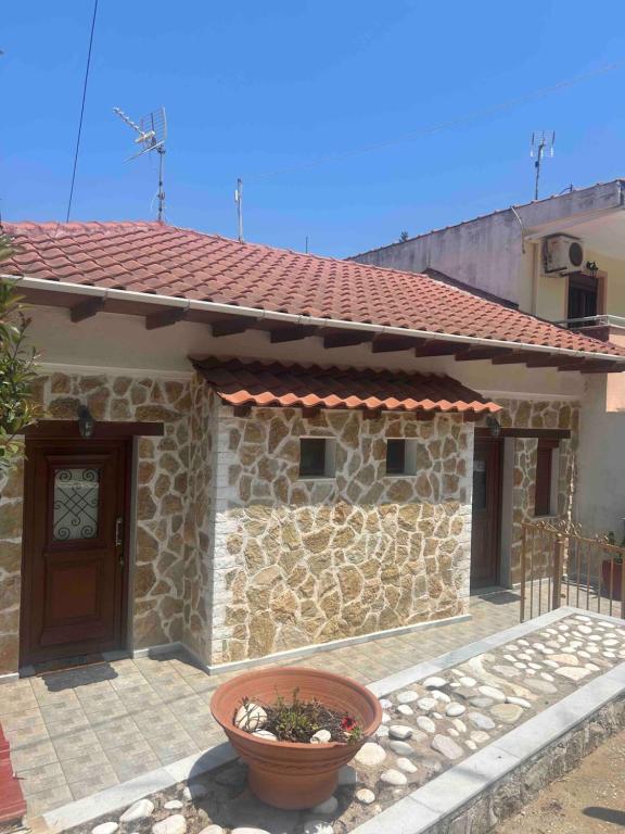a stone house with a door and a planter in front at APARMENTS Elina in Potamiá