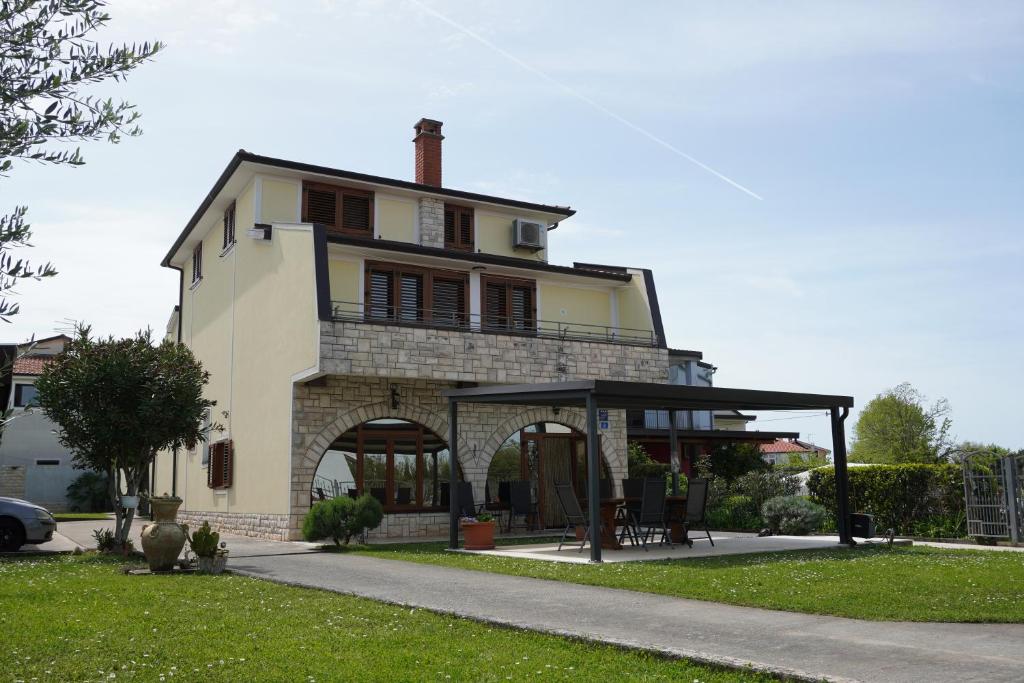 a large house with a gazebo in front of it at Apartments Krnjic in Umag