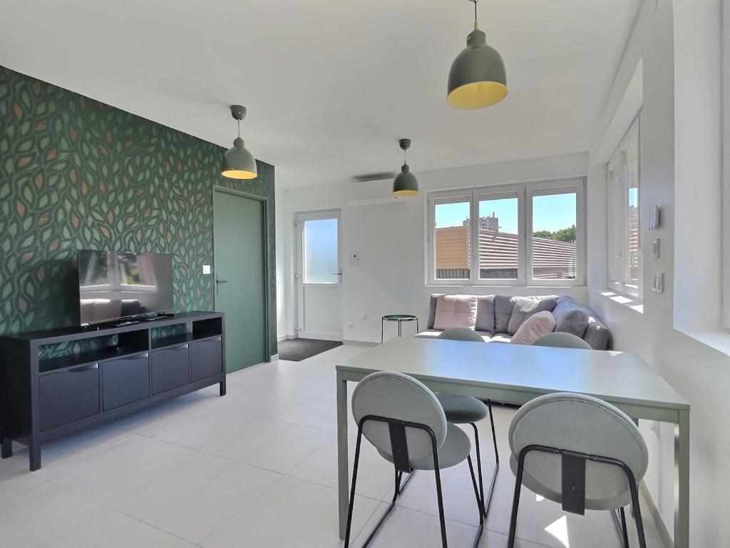 une cuisine et un salon avec une table et des chaises dans l'établissement Le Croisement de Miss K Conciergerie, à Mâcon