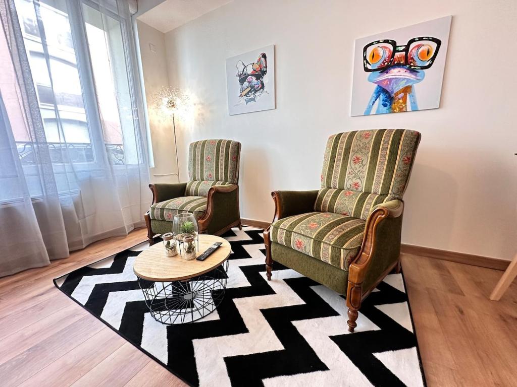 un salon avec deux chaises et une table basse dans l'établissement Le repère dAlice T2 cosy proche centre, à Reims