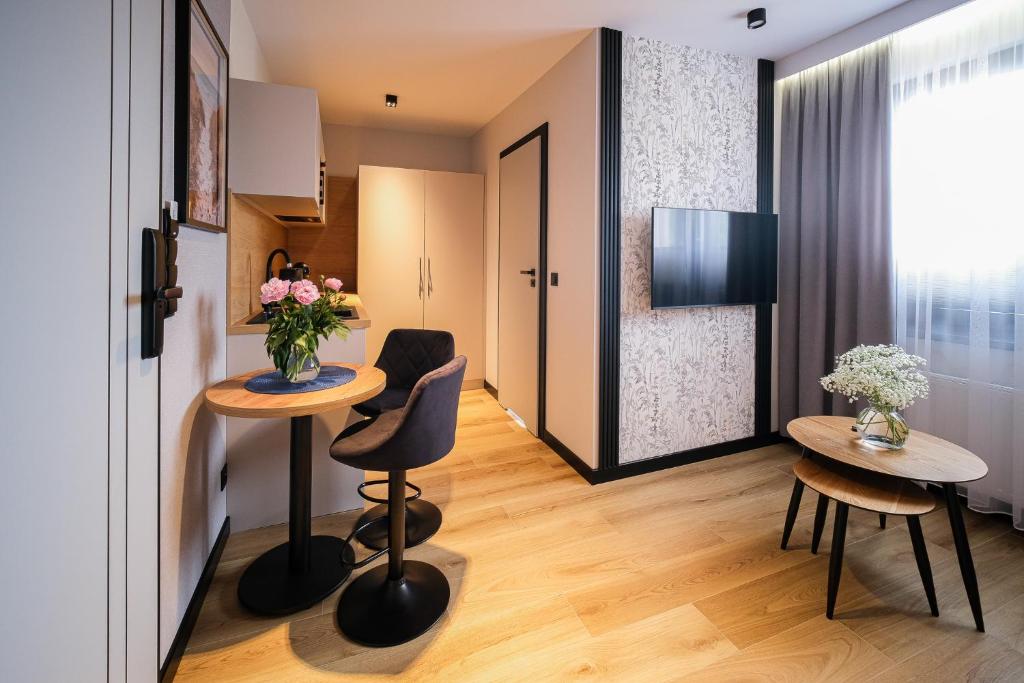 mały pokój z dwoma stołami i dwoma krzesłami w obiekcie Apartamenty i Pokoje Złotobrzeg w Sarbinowie