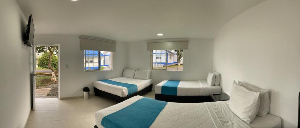 Una habitación de hotel con dos camas y una ventana. en Hotel Villa Mónaco, en Pereira
