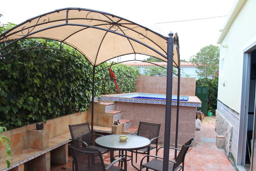 埃爾韋爾赫爾的住宿－Casa La Madriguera，露台配有桌椅和遮阳伞
