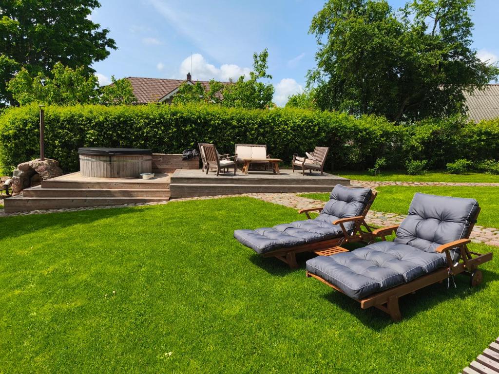 a yard with two lounge chairs and a fire pit at Kur skamba varpai in Berżory