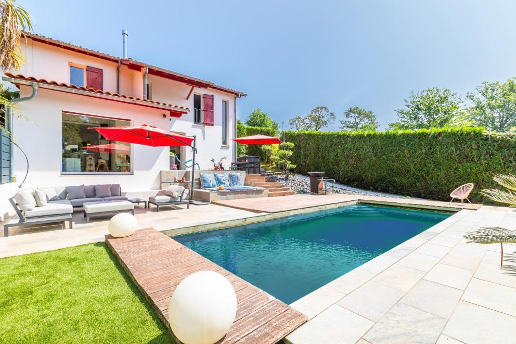 a swimming pool in the backyard of a house at Villa Basoa - Villa avec piscine à 10 min plages in Bassussarry