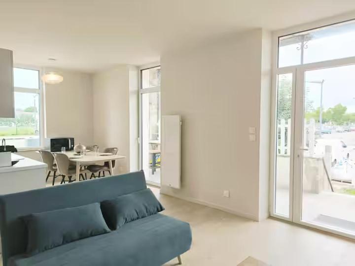 un salon avec un canapé bleu et une table dans l'établissement Le Terrazzo - Jardin & confort, à Meximieux