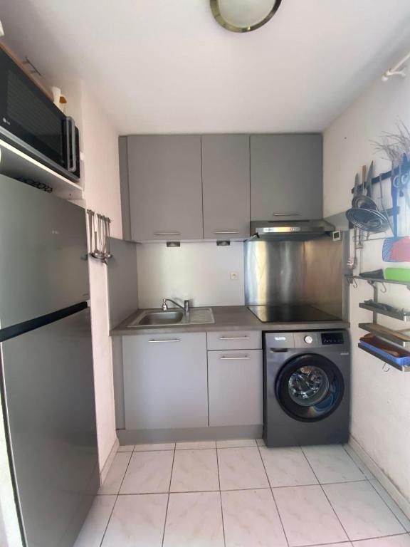 une petite cuisine avec un lave-linge et un lave-linge dans l'établissement Marine Wave, à Aresquies