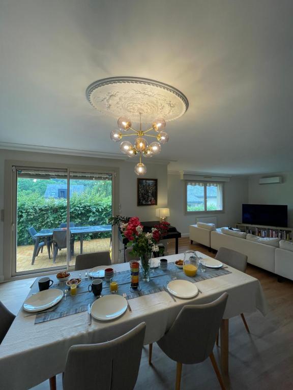 une salle à manger avec une table et un grand lustre dans l'établissement Maison Changé, à Changé