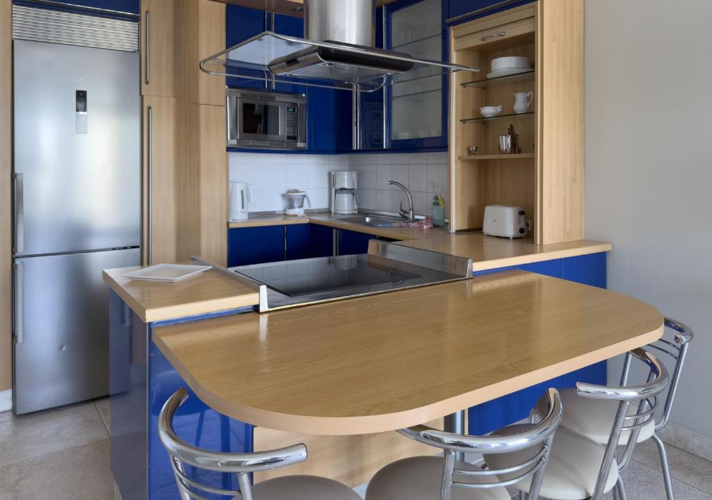 a kitchen with a wooden table and blue cabinets at Holiday Club Vista Amadores in Amadores
