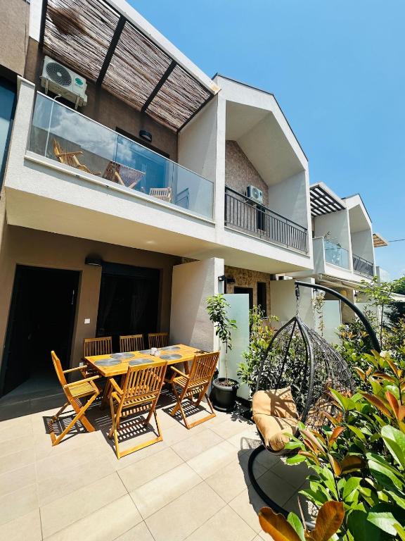 a house with a wooden table and chairs on a patio at Villa Agora in Nikiti