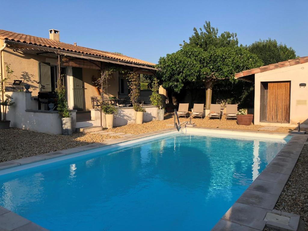 une piscine bleue devant une maison dans l'établissement Haus PETIT REVE in Oppède, à Oppède