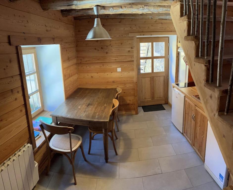 a dining room with a wooden table and chairs at Au Vialaou - Chez Marcelle in Névache