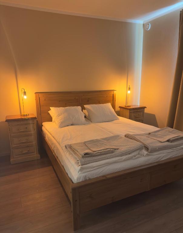 a bedroom with a large bed with two night stands at SteneBo in Stenestad