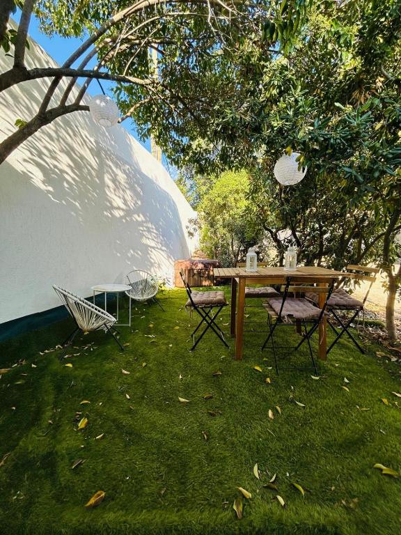 une table de pique-nique et des chaises assises sous un arbre dans l'établissement Maison 10 Cosy T2 avec jardin Jacuzzi, à Marseille