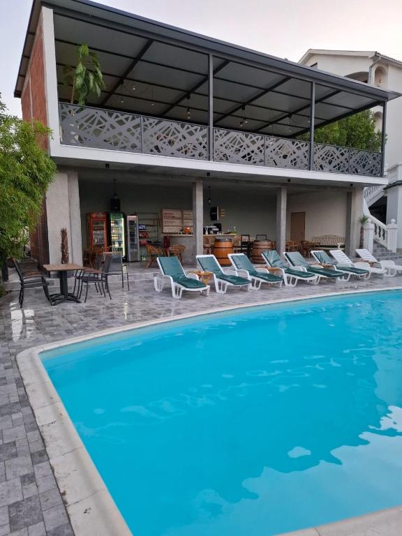 a swimming pool with chairs and a house at City view & pool apartment 2 in Niš