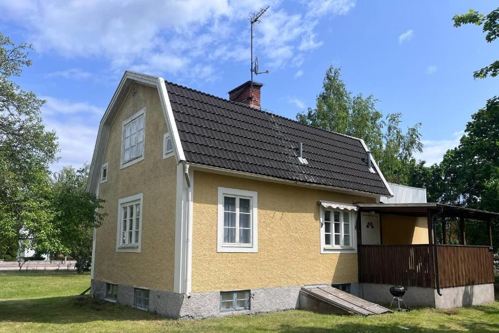 ein gelbes Haus mit schwarzem Dach in der Unterkunft KalmarStay in Ålem