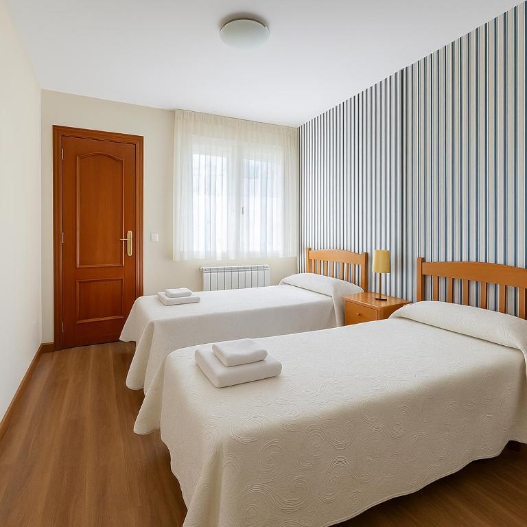 a room with three beds with white sheets at Pension Gelin in Carrizo de la Ribera