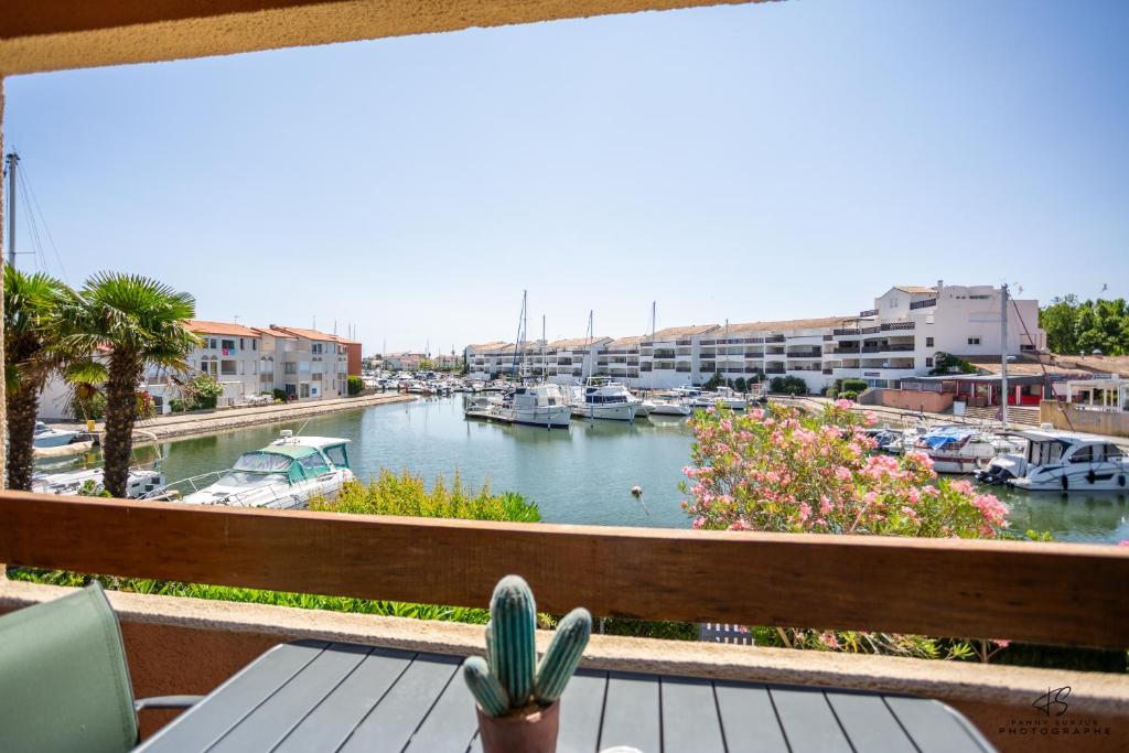 un balcon avec vue sur une marina avec des bateaux dans l'établissement L'Athlantis - Cosy with terrace and parking, à Saint-Cyprien