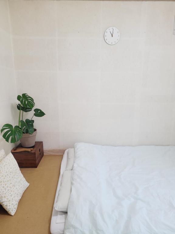 a bedroom with a bed and a clock on the wall at Gyeongju Moon Rabbit in Gyeongju
