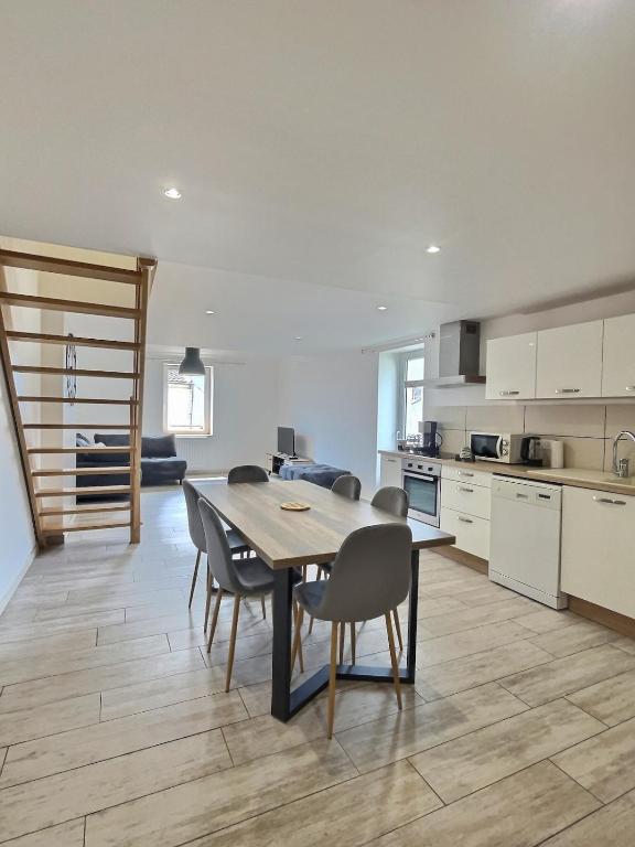 une cuisine et une salle à manger avec une table et des chaises dans l'établissement L'Entre Deux Miss K Conciergerie, à Mâcon