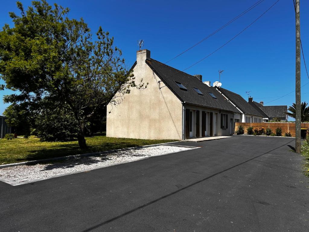 un bâtiment avec un toit noir dans une rue dans l'établissement Maison - Réville avec son boulodrome !, à Réville
