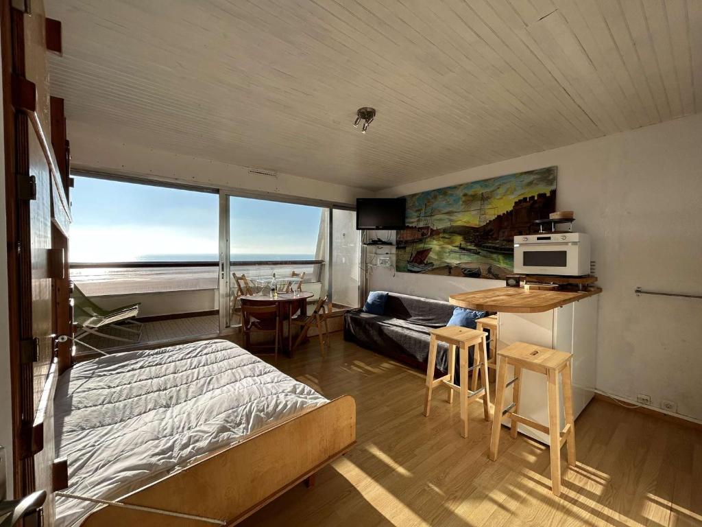 - une chambre avec un lit et une table avec un four micro-ondes dans l'établissement Studio en Front de Mer avec Balcon à Saint-Jean-de-Monts - 4 Couchages - FR-1-224C-286, à Saint-Jean-de-Monts