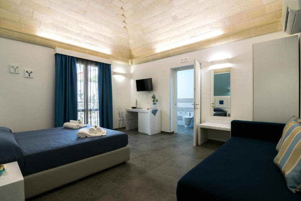 サン・ヴィート・ロ・カーポにあるPharosのベッドルーム1室(ベッド1台、ソファ、デスク付)