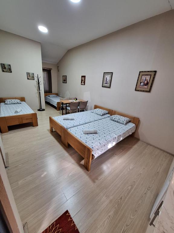 a room with two beds and a table at Goka apartments in Gevgelija