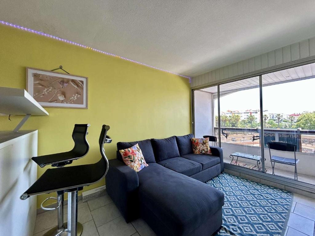 un salon avec un canapé bleu et une table dans l'établissement Studio CAP D'AGDE CT090-274, au Cap d'Agde