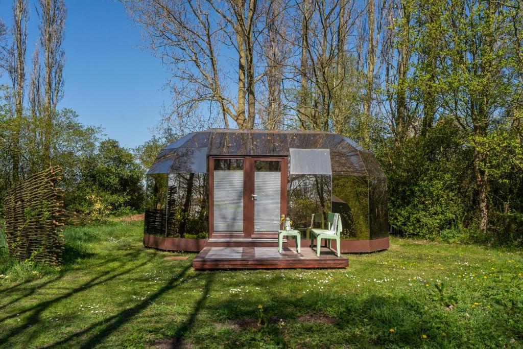 a small dome house with two chairs in the grass at Cabin Fata Morgana in Kats