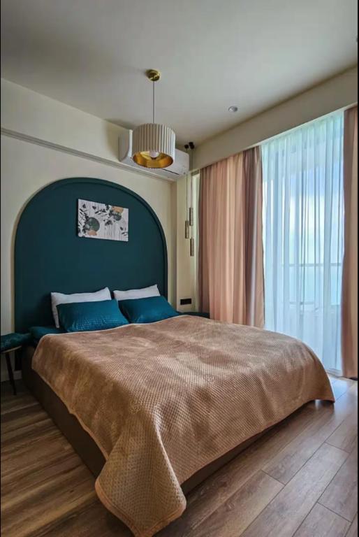 a bedroom with a large bed with blue pillows at MaRKoS Sea View Apartment Bamboo Beach in Ts'ikhisdziri