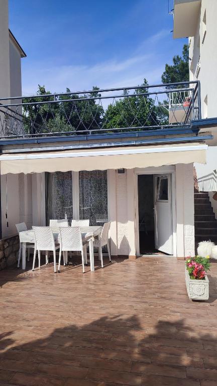 a patio with white tables and chairs in front of a building at APP Tilia in Crikvenica