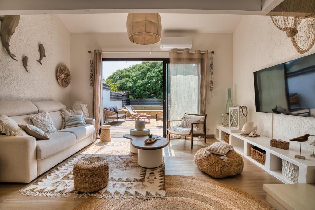 un salon avec un canapé et une télévision dans l'établissement Villa Sel & Sable - Pool - Air conditioning - Beach 200 m, à Seignosse