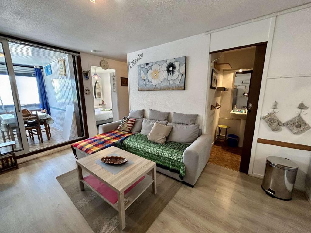 un salon avec un canapé et une table dans l'établissement Appartement cosy avec loggia, proche plage & centre, 4 couchages à Saint-Cyprien - FR-1-225D-201, à Saint-Cyprien
