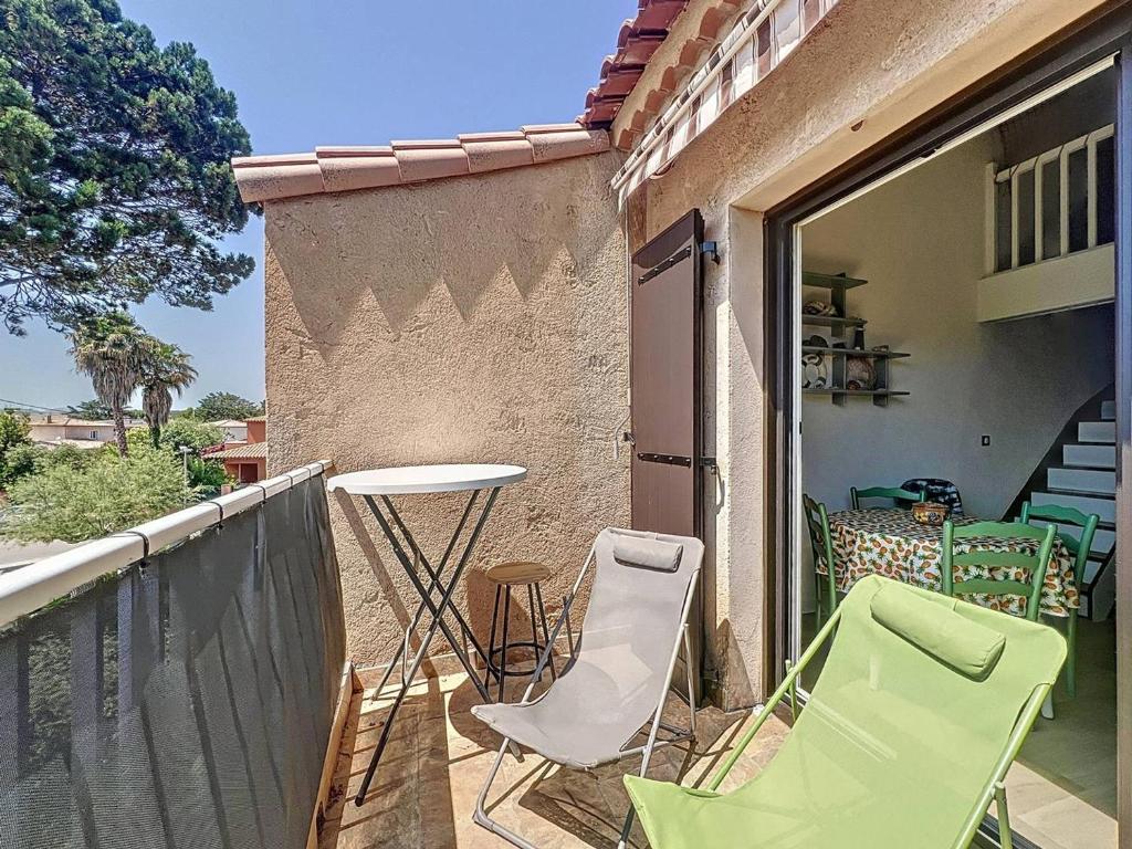 un patio avec des chaises et une table sur un balcon dans l'établissement Appartement à Saint-Cyr-sur-Mer proche plage avec clim et parking privé - FR-1-770-45, à Saint-Cyr-sur-Mer