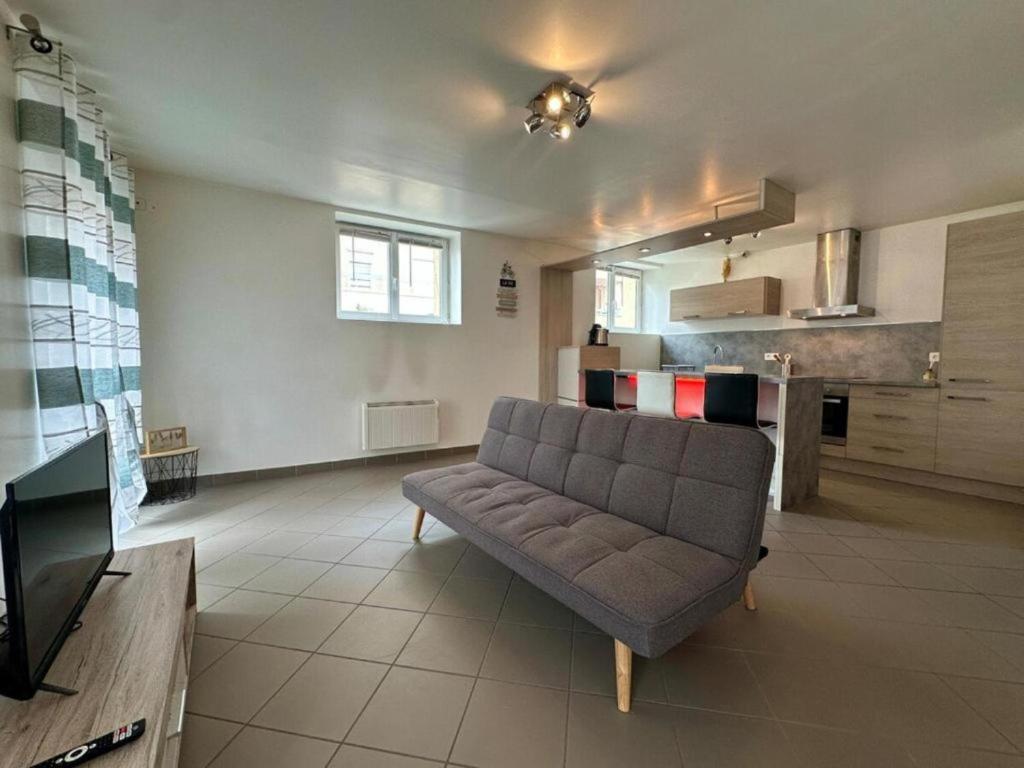 un salon avec un canapé et une cuisine dans l'établissement Le logis du chevalier saint-jean, au Puy-en-Velay