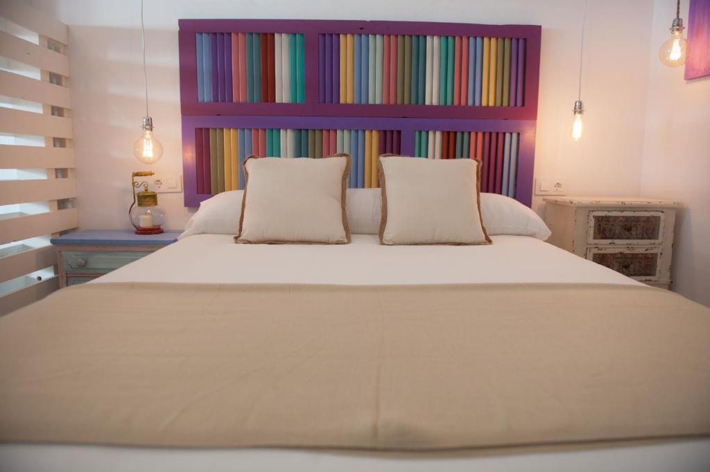 um quarto com uma cama grande e uma cabeceira colorida em Alhanía Vejer em Vejer de la Frontera