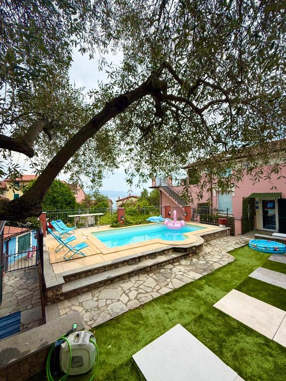 a backyard with a swimming pool and a tree at Innovation House in La Spezia