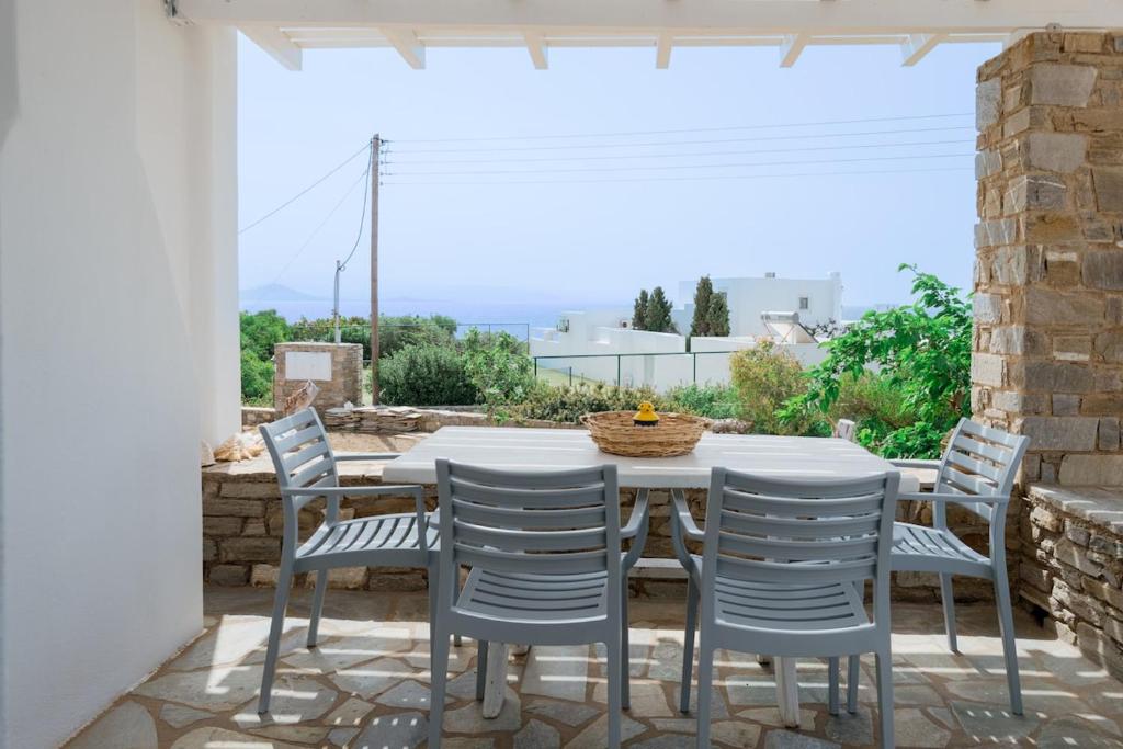 a white table and chairs on a patio at Traditional Cycladic Home Paros in Naousa