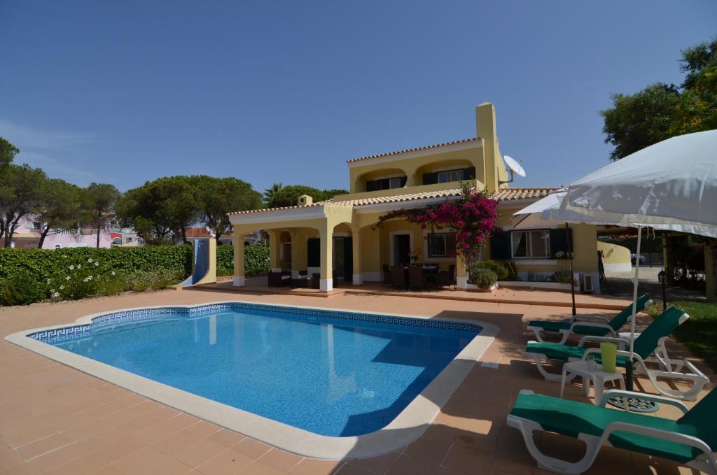 Casa con piscina, sillas y sombrilla en Bonita en Quarteira