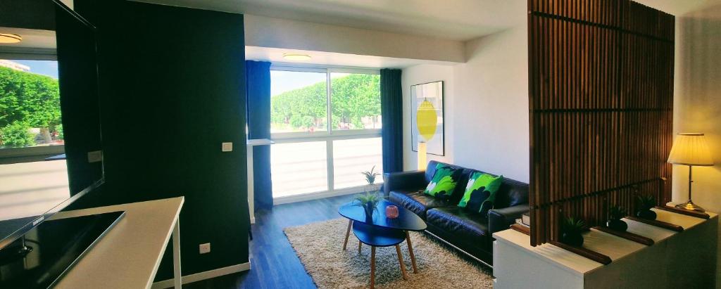 un salon avec un canapé et une table dans l'établissement Le Voltaire, Joli Studio, proximité de la Gare et du Centre, Climatisé, à Sète