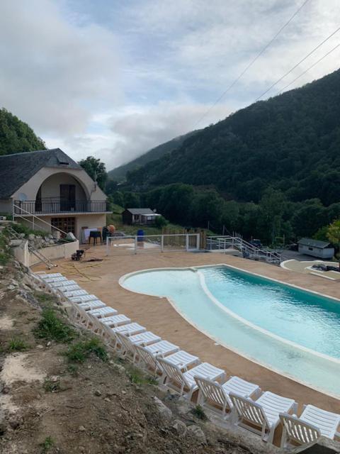 - une piscine avec des chaises longues à côté d'une montagne dans l'établissement Mobil-home 6 personnes 2CH 44m2, à Arreau