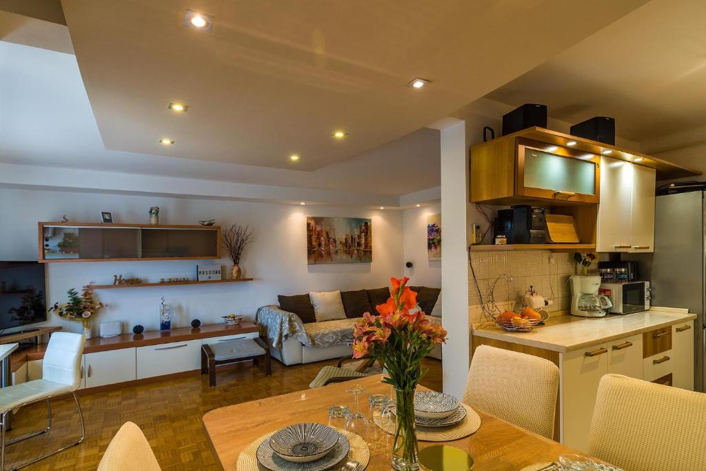 uma cozinha e sala de estar com uma mesa e um sofá em Apartment Many em Pula