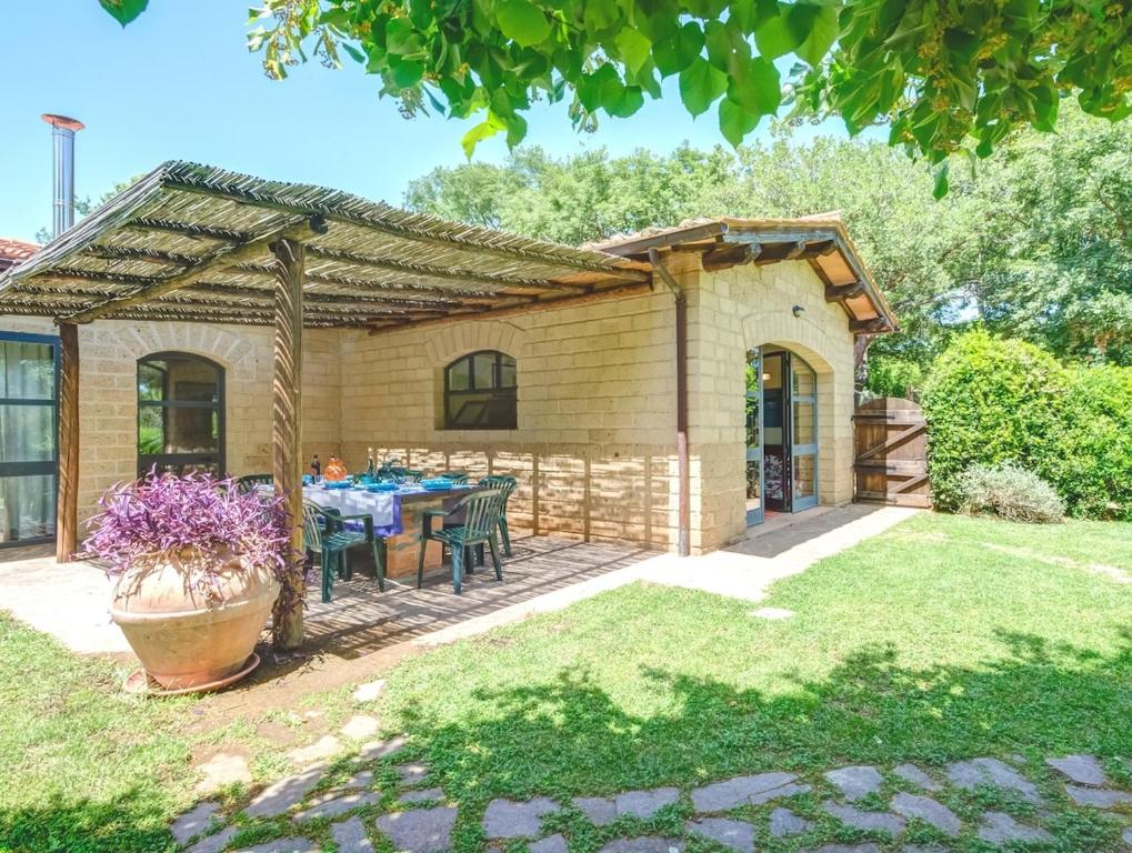 a patio with a table and chairs in a yard at Grande, bella villa in Toscana vicino al mare in Capalbio
