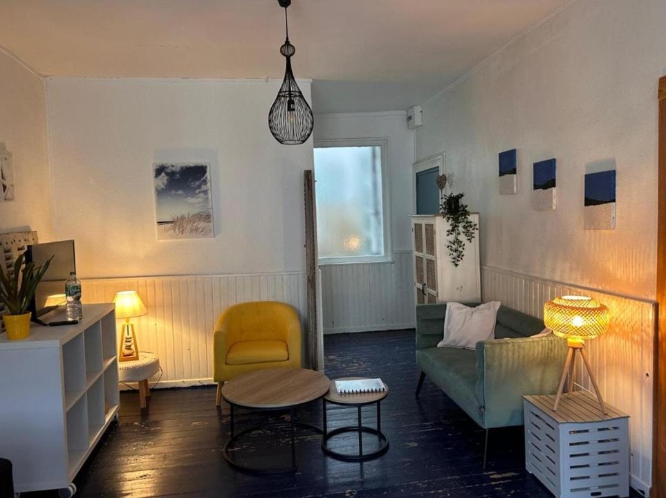 un salon avec un canapé et une chaise dans l'établissement Cabine de la plage 2, à Fécamp