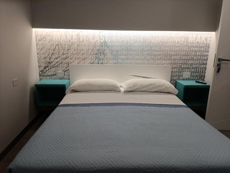 sypialnia z łóżkiem z 2 szafkami nocnymi i awrtisement w obiekcie Garden Gafè w mieście Diamante