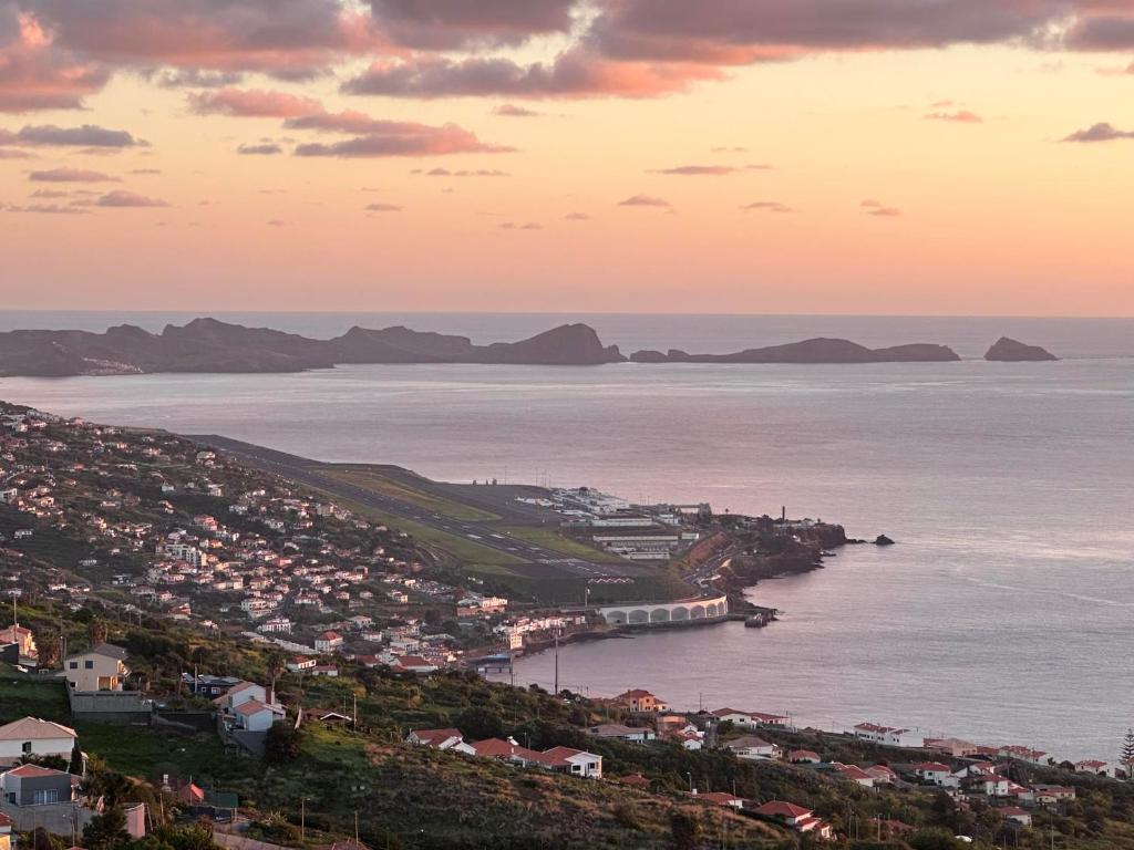 a view of a city and the ocean at sunset at Sea View Andrade 3 Bedroom House in Gaula
