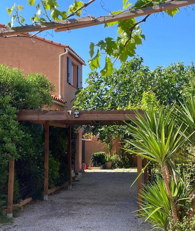 une pergola en bois devant une maison dans l'établissement Charming mediterranean house, à Villelongue-de-la-Salanque