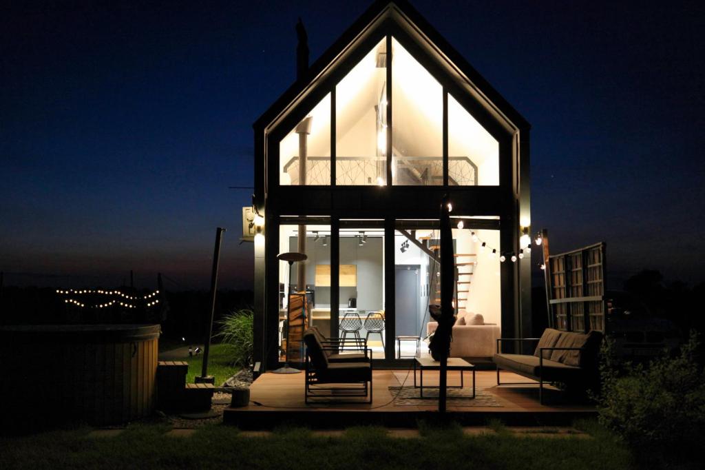 a house with a large glass facade at night at Dolina Słońca obok Suntago - nowoczesne domy z jacuzzi in Benenard